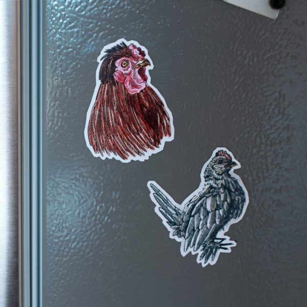 Rooster magnets shown on the side of a fridge