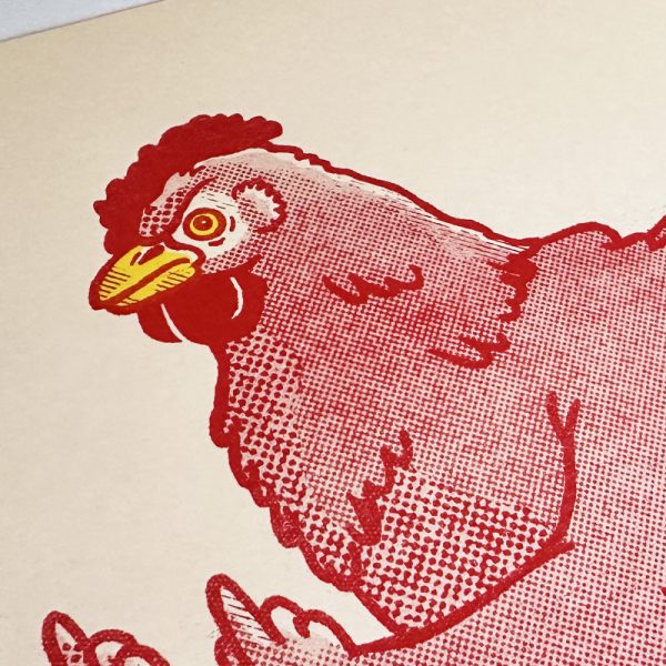 Close-up photo on the face of the chicken illustration, showing halftone texture